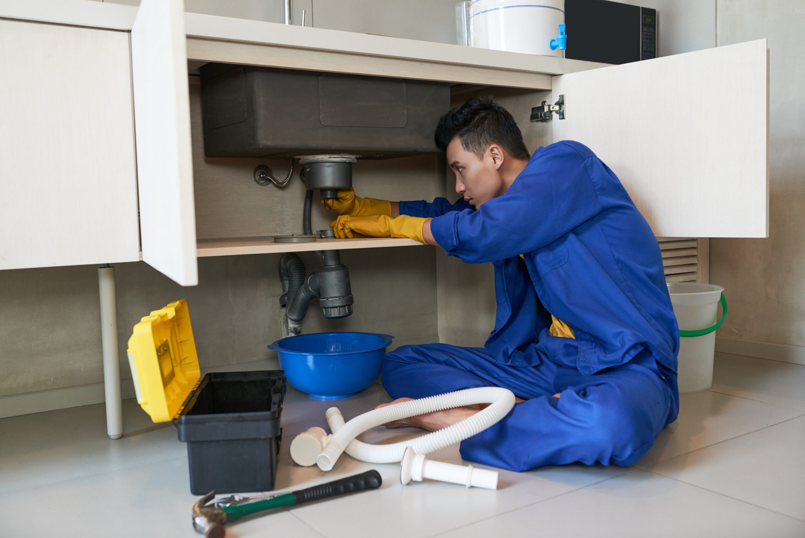 plumber checking drain in kitchen